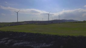Aerial video of wind turbines ascending towards the sky. Drone video of wind turbines in fields.