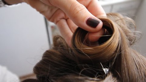 Close up shot of woman's hands. Woman holding case with barrettes in white make up room. Beauty and haircare concept. close-up. the view from the top. heat styling with a Curling iron to the hair