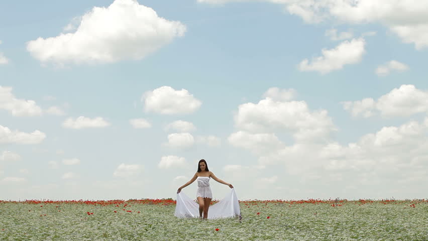 Young Woman With White Scarf Walking In a Field