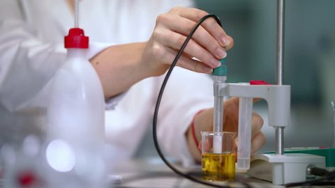 Scientist hands working with laboratory equipment. Closeup of female scientist working with chemical liquid. Woman working with ph meter in lab