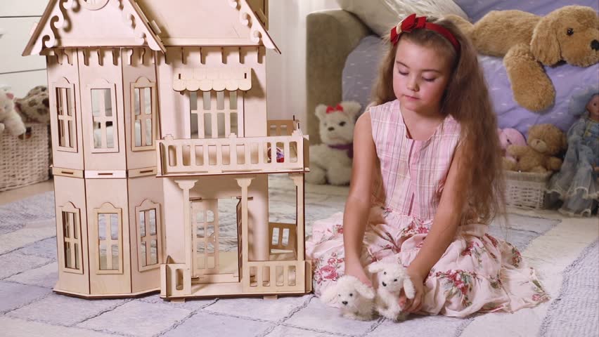 girl playing with dollhouse