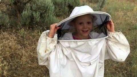 A little girl wears an oversized bee suit.