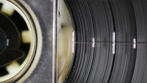 Spinning magnetic tape in tape drive. Seamless loop. 4K, static macro shot. Close up of audio cassette tape in use sound recording in a cassette player

