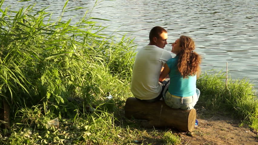 Loving couple looking eye to eye near water