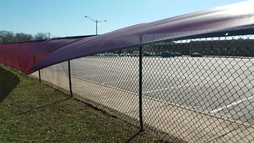 red banner flapping in the wind on a fence