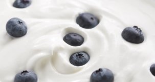 Blueberries in organic yogurt rotating loop video, 4k prores footage