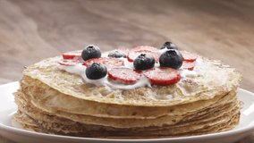 Slow motion of sprinkling sugar powder on blinis or crepes with fresh berries, 180fps prores footage