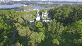 St. Michael Vydubitsky male monastery in Kiev, Ukraine. Flying on copter over the church against the backdrop of the city of Kiev and the Dnieper River . Aeril view. Video 4k