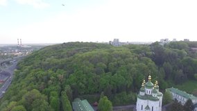 St. Michael Vydubitsky male monastery in Kiev, Ukraine. Flying on copter over the church. Aeril view. Video 4k. Video with the passing plane coming in to land