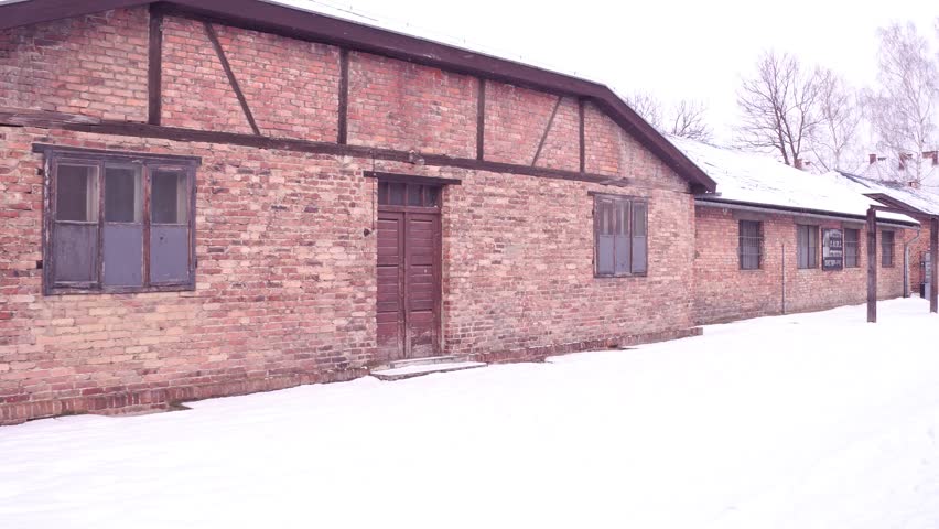 Steadicam shot of concentration camp brick building in winter. 4K clip