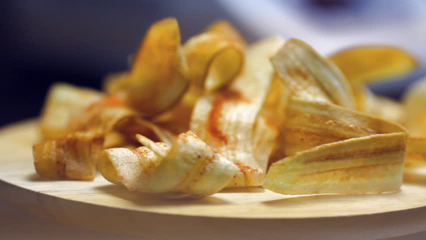 Plantain Chips spinning on a wooden plate