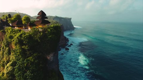 Pura Uluwatu temple. Stone cliffs, ocean waves and oceanscape. Aerial top view. Bali, Indonesia.