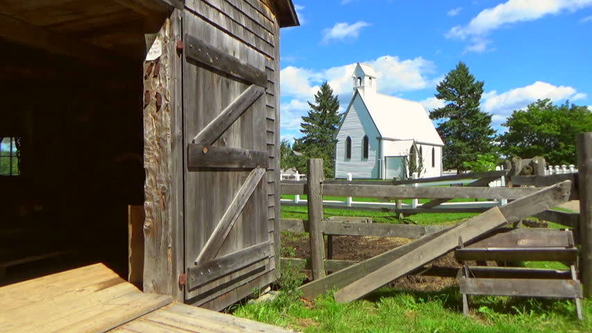 Historic village with farmhouses in Canada. Old Church exterior. Picket fences.