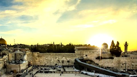 Sunrise time lapse at the Jerusalem's Western/Wailing Wall, as the Jewish people gather for Shacharit prayer at the holiest place in Judaism; the muslim Al Aqsa mosque and Mount of Olives in the back
