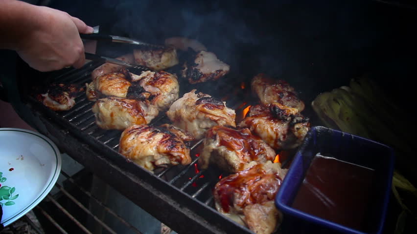 Grilling chicken on an outdoor barbecue grill.