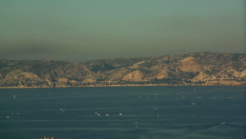 Marseilles, France - CIRCA October 2009: Large panoramic view of mountains and hills surrounded by water with many sailing boats; city