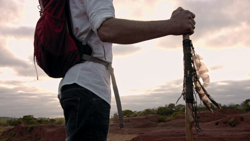 4k close up of walking stick in desert mountain terrain at sunset with sun flare. 