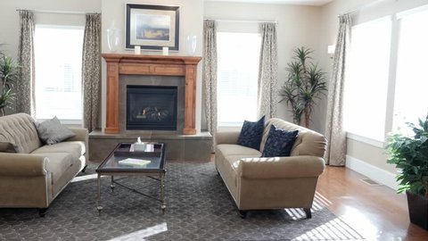A dolly shot of a modern and beautiful room with a fireplace and couches