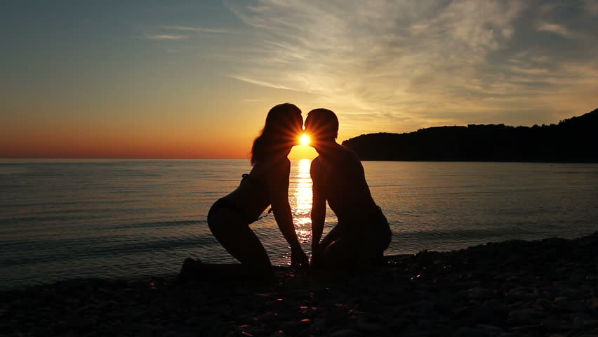 Couple on the shore of the sea, Romantic Couple at Sunset. Two people in love at