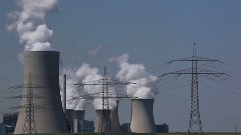 Brown coal power plant with huge cooling towers and steam