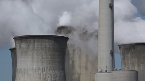 Brown coal power plant with huge cooling towers and steam
