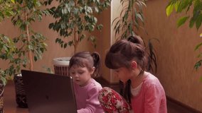 Little sisters with laptop. 