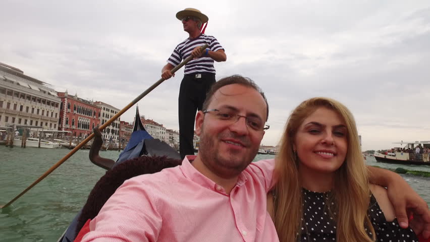 Beautiful lovers couple in Venice on Gondola ride. Romance shot in boat. Happy together on travel vacation holiday in Venice, Italy