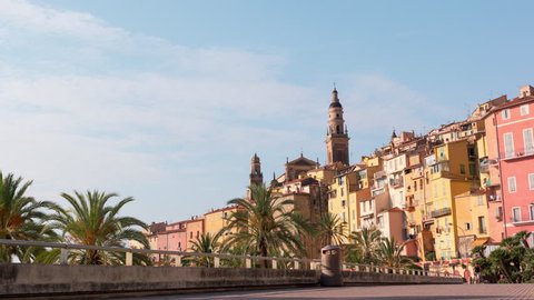 MENTON, FRANCE - SEPTEMBER 2016: Beautiful timelapse of old town Menton on french Riviera, France. Promenade, old houses and the baroque basilica on the hill of Saint-Michel-Archange in the distance
