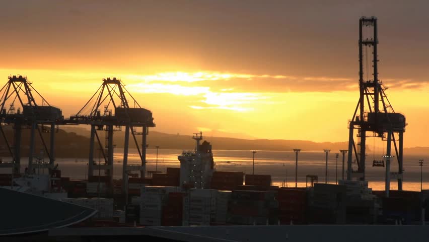 Sunrise over Auckland harbour and Port facility with its gantry cranes.