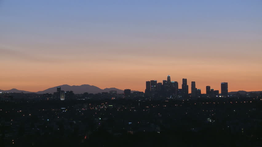 Downtown Los Angeles skyline at sunrise with heat haze and mountains in the