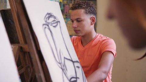 School of art, college of arts, education for group of students. Happy latino young man smiling, learning to paint for job, profession, hobby