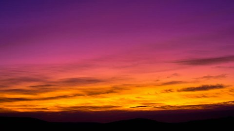 Wispy airy cirrus sparse clouds day to night time lapse. Billow disappear midair cloud scape. Mid air aero ozone stratosphere timelapse. Purple orange red sunset sky. Fantastic golden hour sky roll 4K