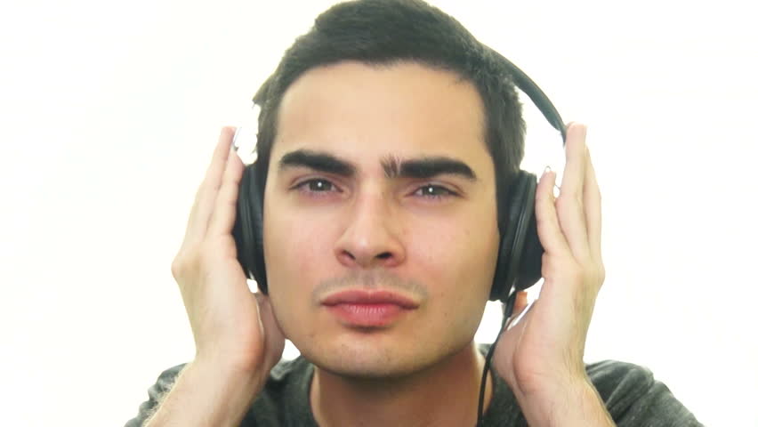 Young man enjoying the music with his headphones on white background.