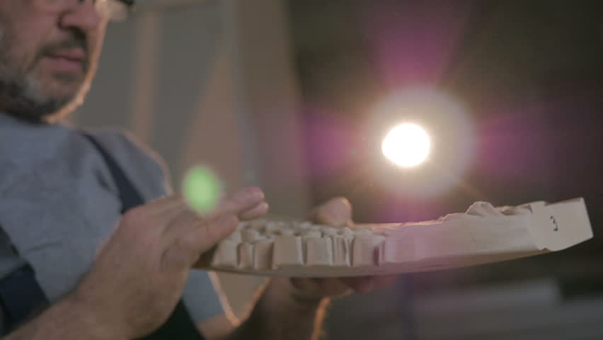 Slow motion close-up shot carpenter leads hands and looking carving wooden detail for furniture in the work shop