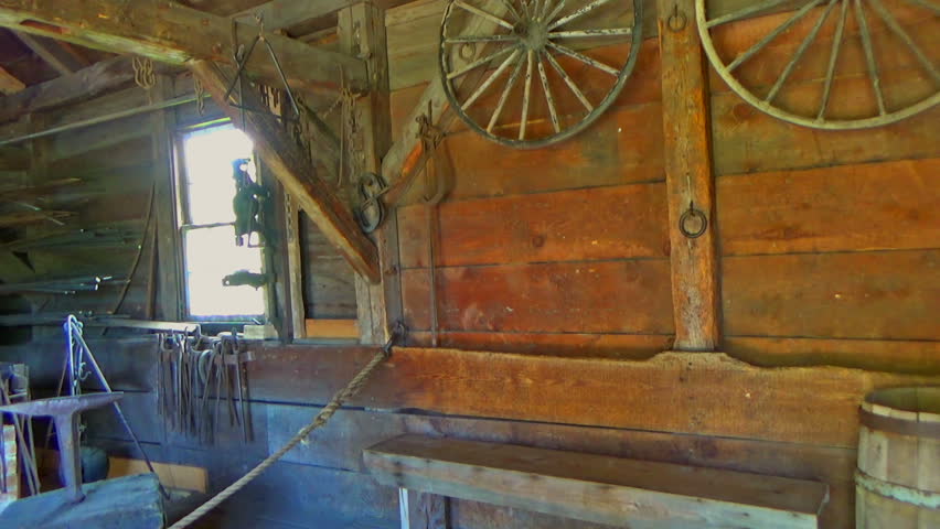 Historic village with farmhouses in Canada. Interior with wooden and iron tools in old historic house cottage or stable