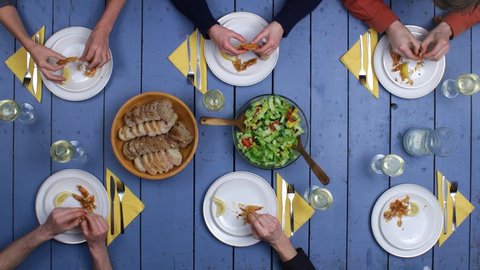 Preparation of grilled fish and fresh vegetable salad. Top view on people eating meal and drinking vine together on rustic mediterranean table setting. Long Stop motion & Timelapse shot. : vidéo de stock