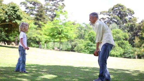 Boy playing with his grandfather in a park