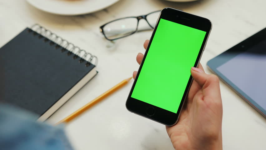 Close-up of woman hands using smartphone with green screen. Close up video of woman