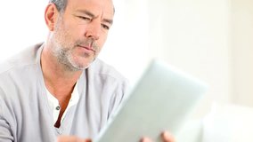 Senior man using electronic tablet
