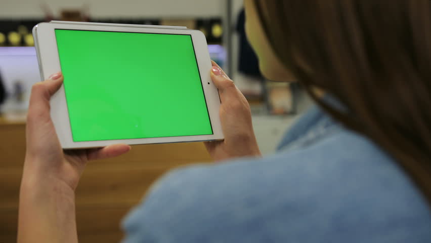 Young beautiful woman watching video on tablet with green screen in the cafe. Close-up. Chroma key. Greenscreen Royalty-Free Stock Footage #23854303