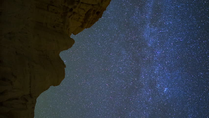 Astrophotography timelapse of star trails over sandstone canyon walls at Red Rock Canyon State Park in Mojave Desert, California -Vertical Shot-