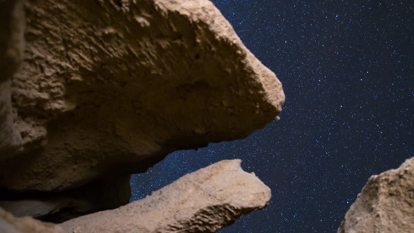 Motion controlled astrophotography timelapse with dolly tracking motion of starry sky through eroded sandstone canyon formation at Red Rock Canyon State Park in Mojave Desert, California