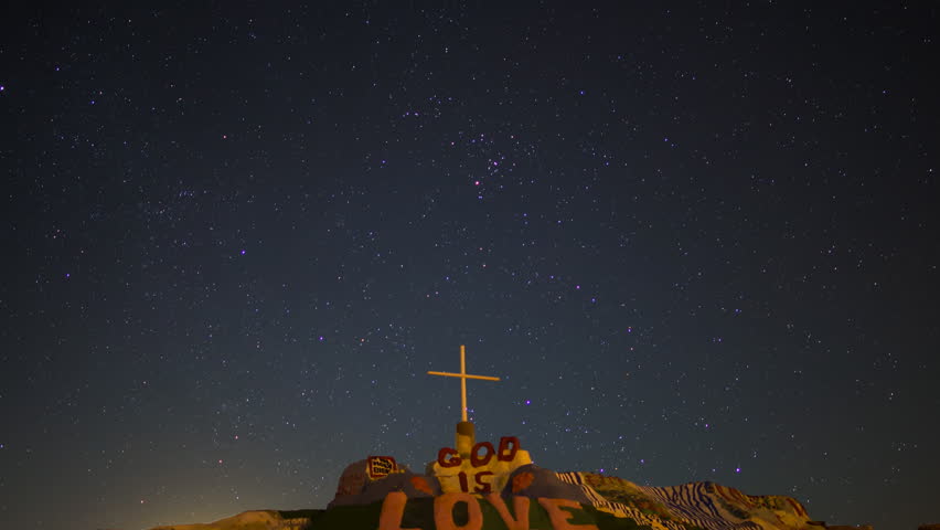 Astrophotography timelapse with tilt down motion of Moon rising over Salvation Mountain in Slab City, California