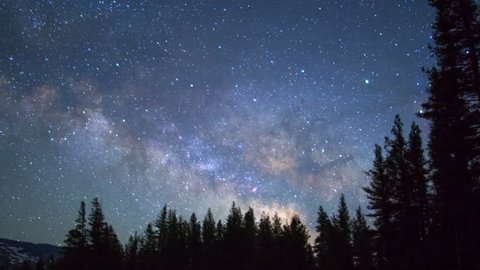 Motion controlled astro time lapse with pan right motion of milky way galaxy over alpine forest in Yosemite National Park, California -Long Shot-
