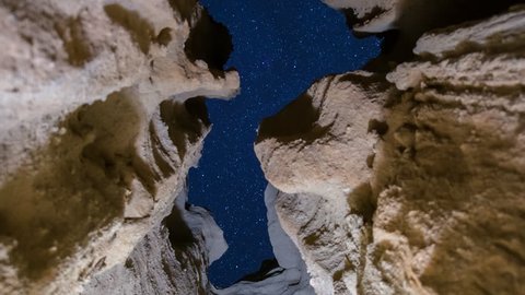 Motion controlled astrophotography timelapse with dolly tracking & zoom out motion of starry sky through sandstone slot canyon at Red Rock Canyon State Park in Mojave Desert, California