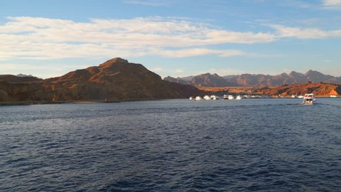 Mooring boats in the bay against the backdrop of the mountains. View from the sailing ship