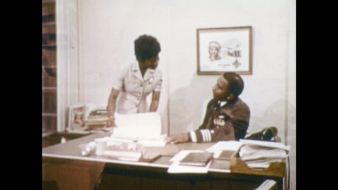 UNITED STATES 1970s: Navy employees work in office. Lady shows paperwork to man at desk. Female recruits in Navy learn electronics.
