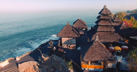 Tanah Lot Temple on the rock in Sea. Ancient hinduism place of worship. Sunlight. Aerial view. Bali, Indonesia
