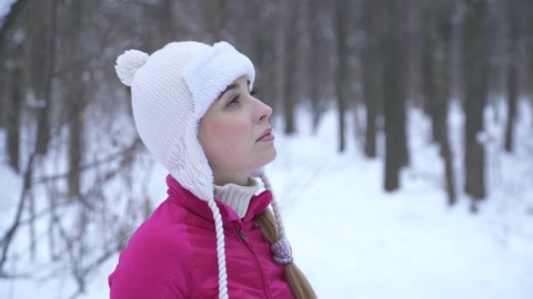 Closeup of young woman making photos with photocamera in winter forest