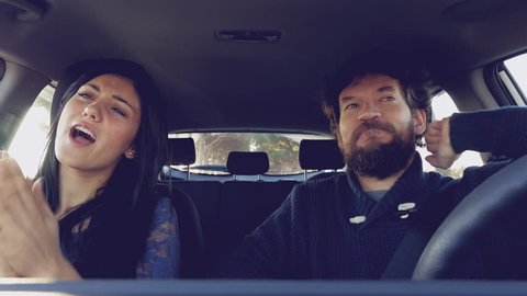 Happy sweet couple singing in car 